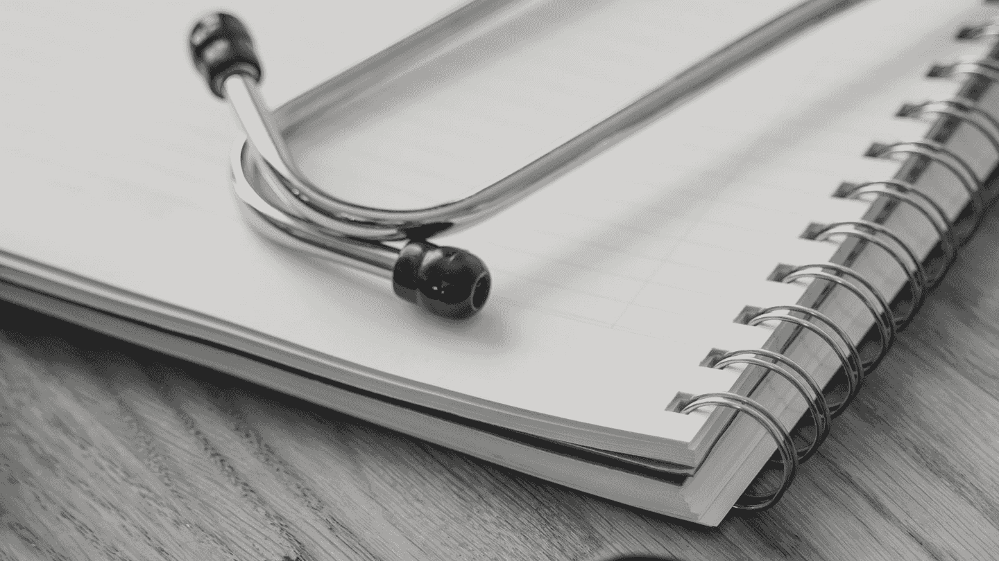 A stethoscope lying on an open notebook.