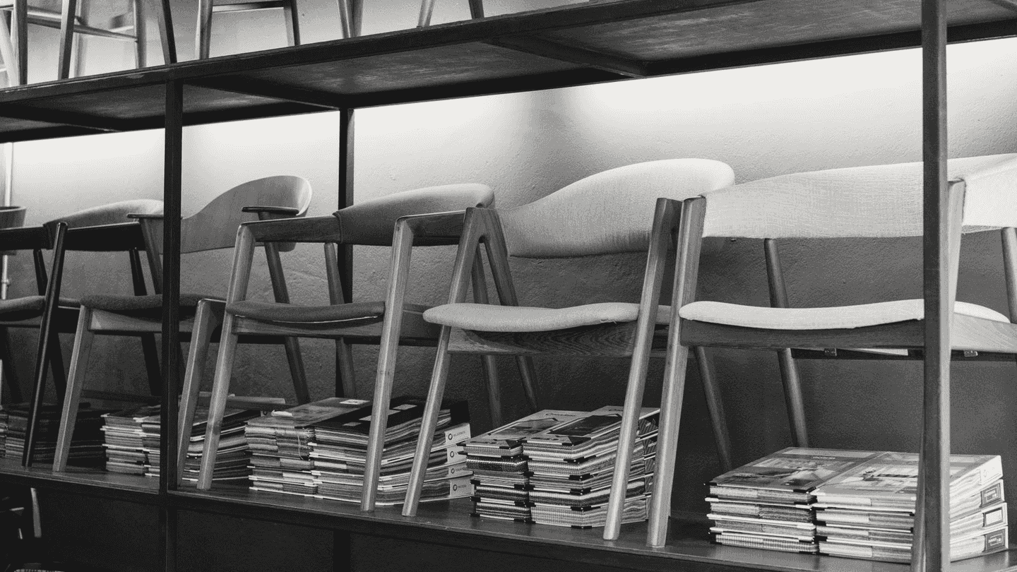 Wooden chairs lined up on a display shelf.