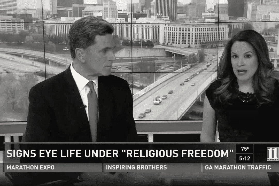 The 11Alive news desk in Atlanta, two anchors under the banner: Signs eye life under religious freedom.